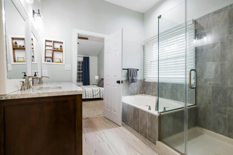 a bathroom with a bathtub next to a sink and glass shower door