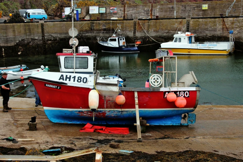 a small fishing boat sitting next to a man