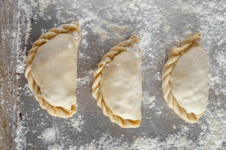 three pieces of pastry dough on top of a baking sheet