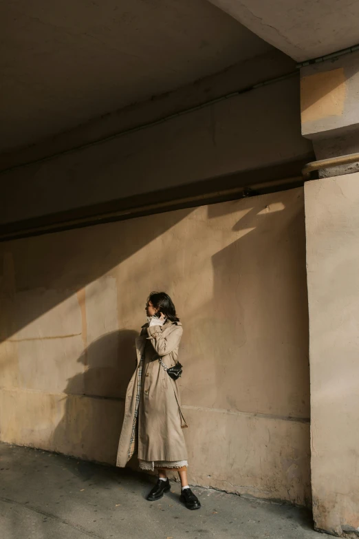 a woman standing in front of an arch while talking on her cellphone