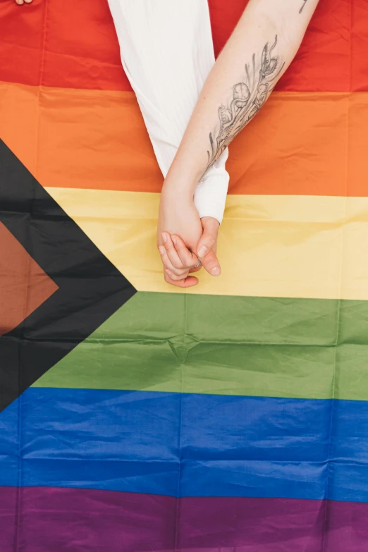 a woman with her arm wrapped around a rainbow flag