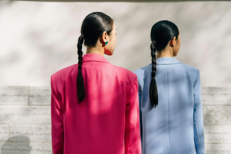 two women are standing together and facing each other