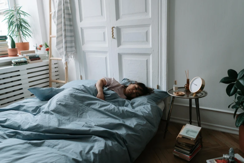 there is a small child sleeping on a big blue bed