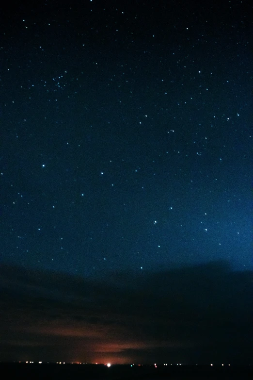 a person sitting on a beach under a starr filled sky