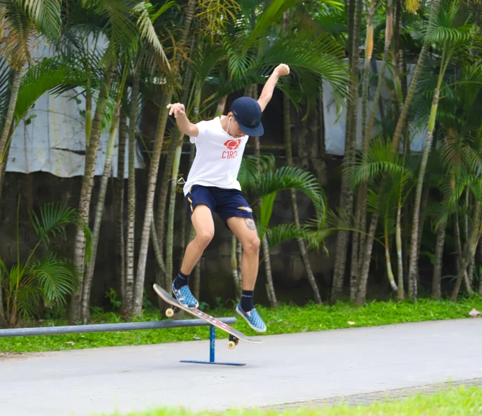 a young man performing a skateboard trick on a blue rail