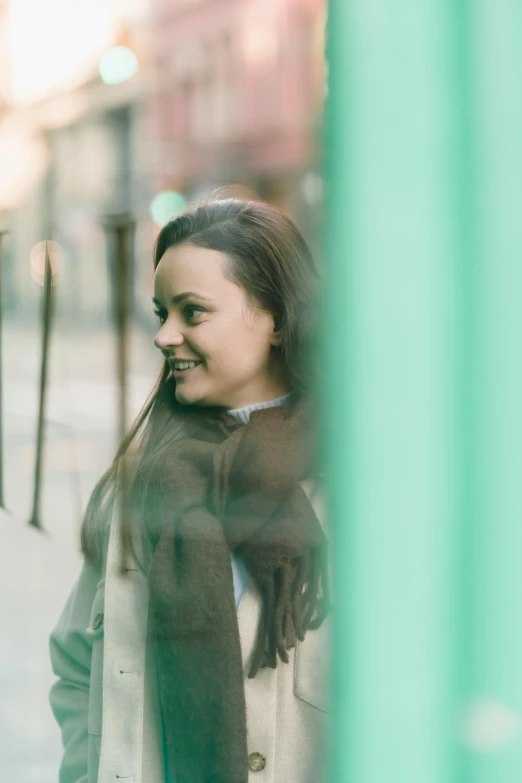 a young woman stands on the sidewalk and smiles