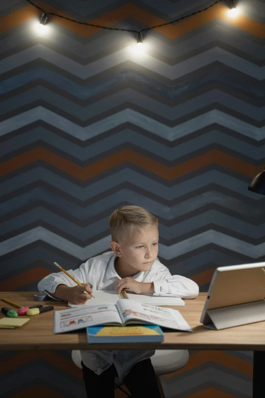 the young child is learning at his desk