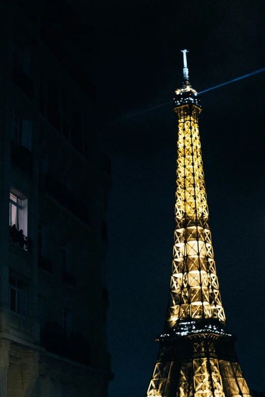 the illuminated eiffel tower sits high in the dark