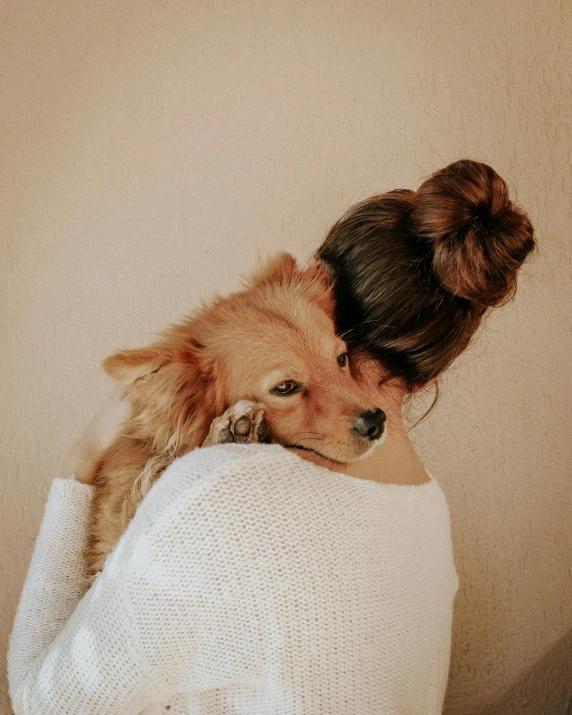 a woman and her dog hug while one holds on to it
