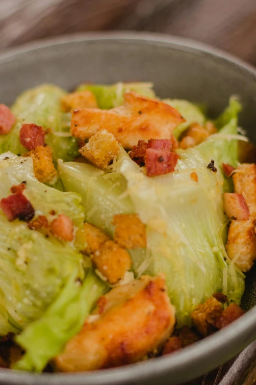 a bowl containing lettuce and some fried vegetables