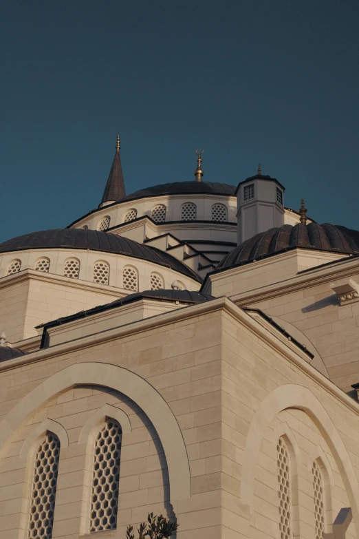 an old white church with a dome and a clock on it