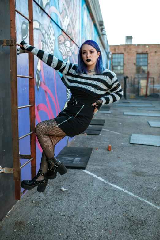 a beautiful woman leaning against a wall with graffiti on it