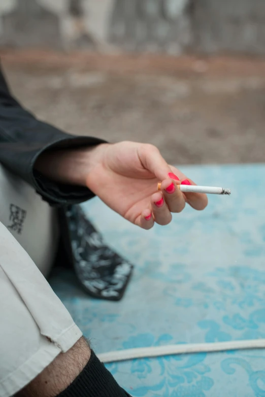 a woman smoking a cigarette on a bed with blue mattress