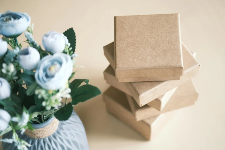 some pretty blue roses in a gray vase and brown paper bags