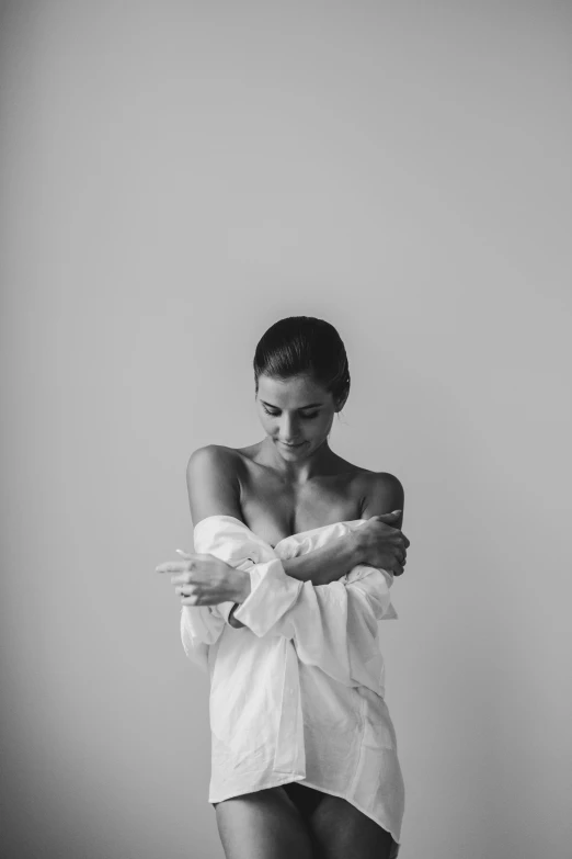 a  woman is wearing a white robe and has her arms folded around her