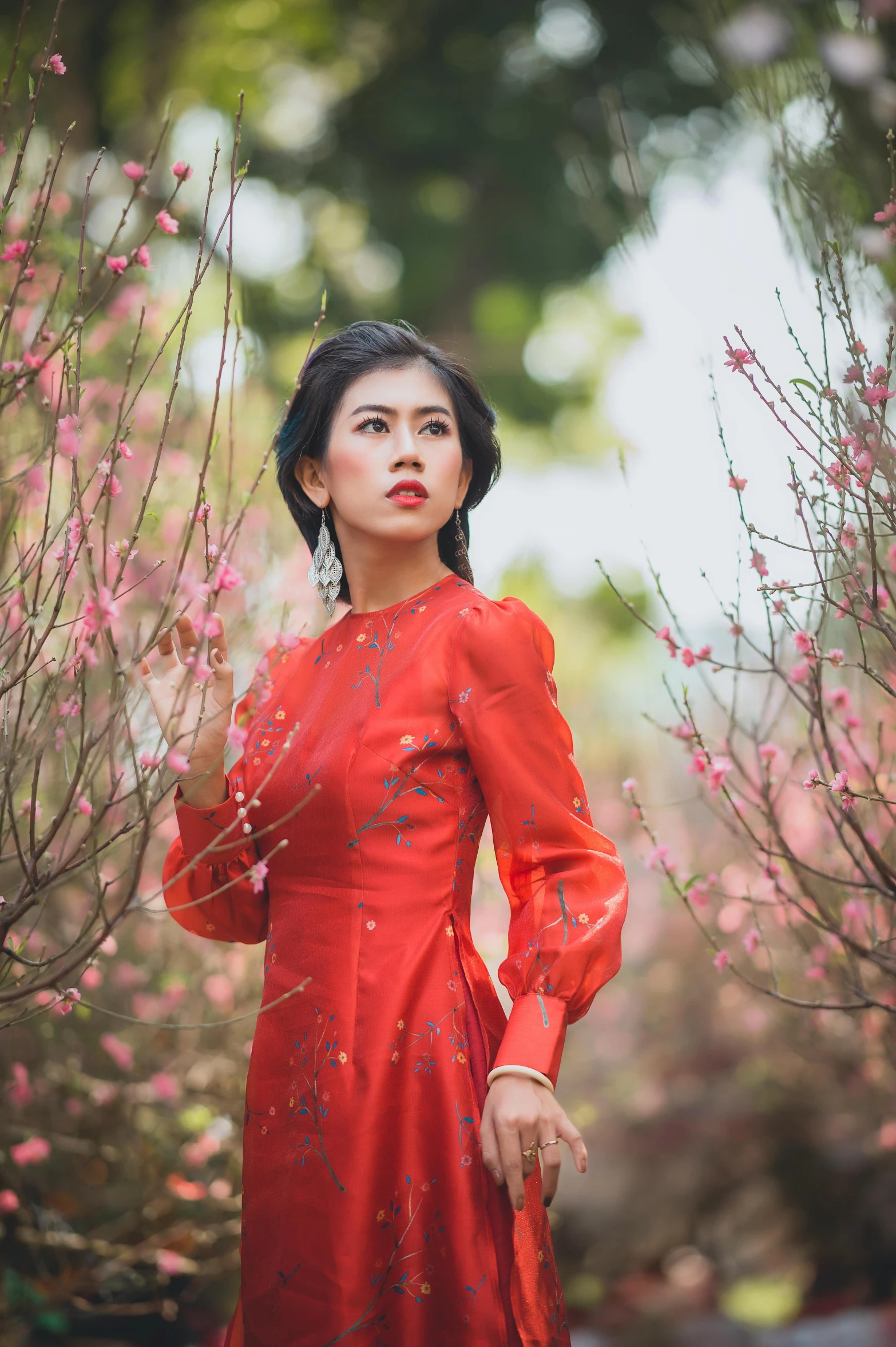 a woman posing in front of a tree