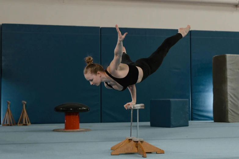 a female pole diving competition winner doing a handstand