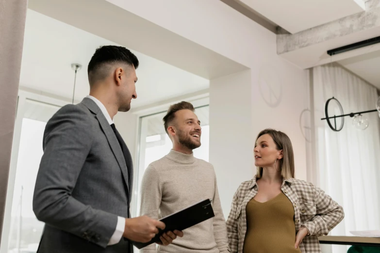 a man and two women standing by each other talking