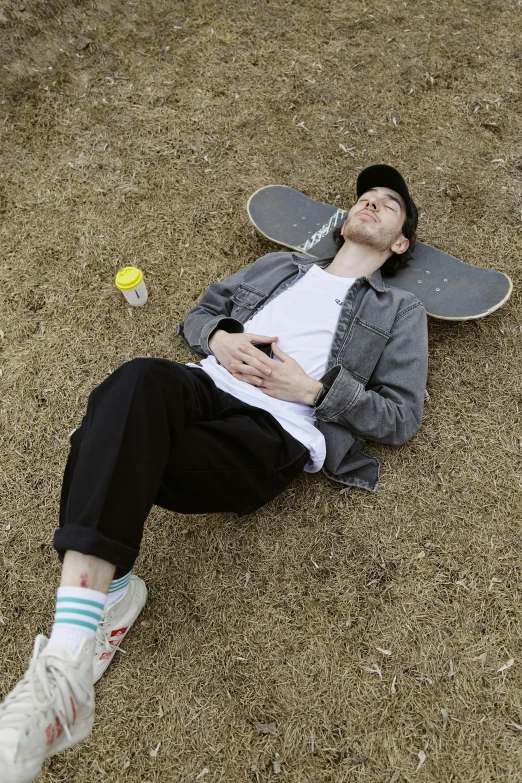 a man laying on the ground near a skateboard