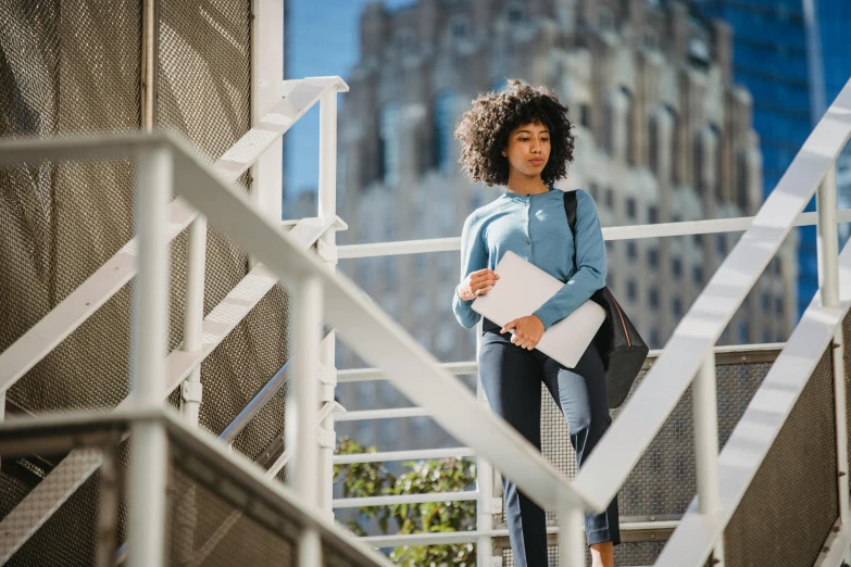 woman walking up steps with books in hand