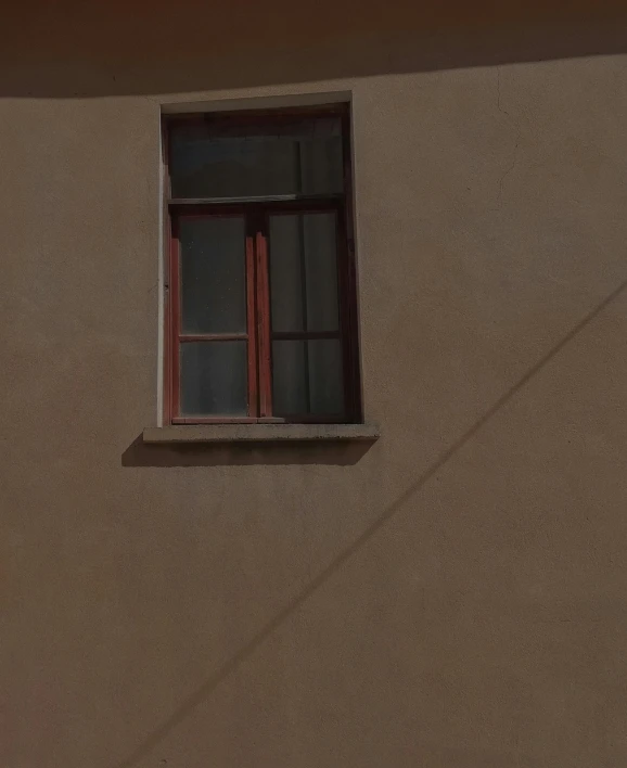 a small window on the side of a beige building