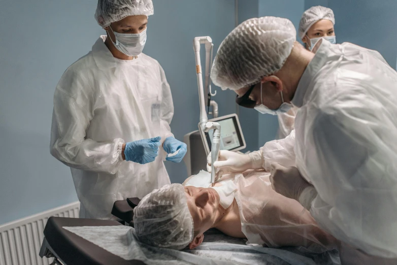 three medical personnel attending to an infant in a hospital