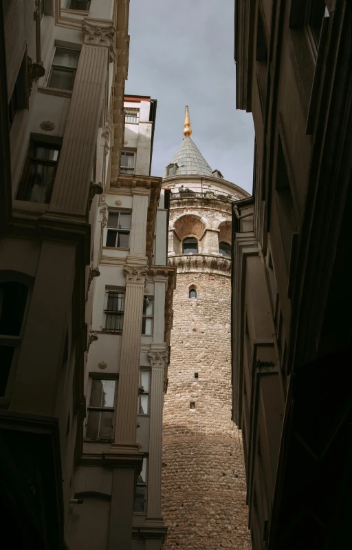 a clock tower seen through several buildings in the city