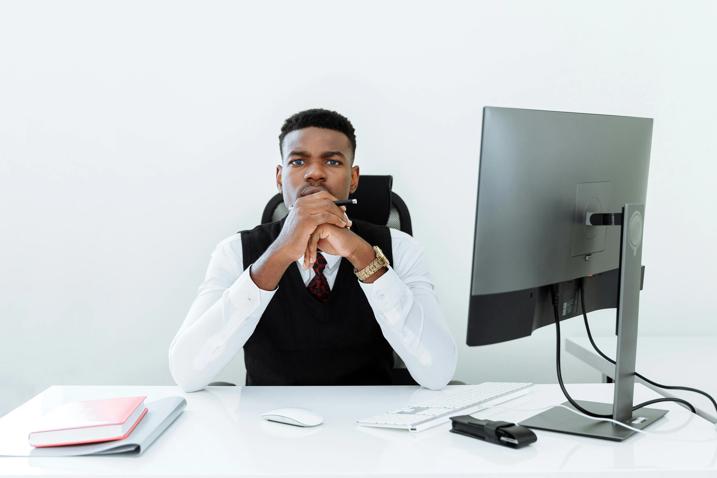 a man with a watch is sitting in front of his desk