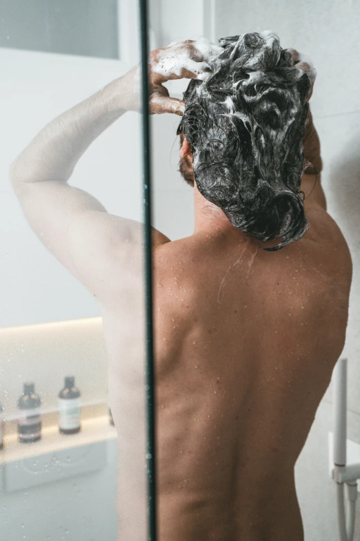 a man is shaving his hair in the bathroom