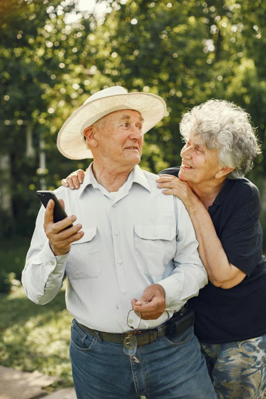 two people standing in a park with one man touching his arm around the other