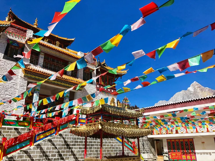 a colorful, asian building with flags in the air