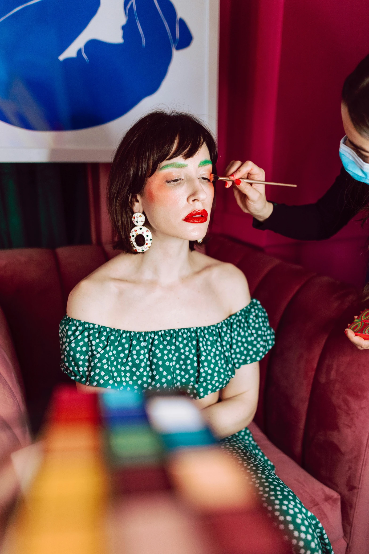 a woman in a polka dot dress is getting her make up
