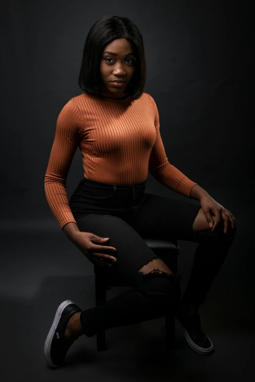 an african american woman in black pants and an orange shirt