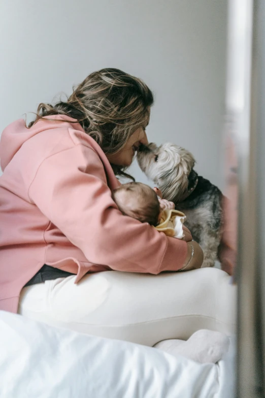 a woman and dog in the bed with white sheets