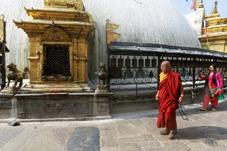 there are two monks that are walking by the structure