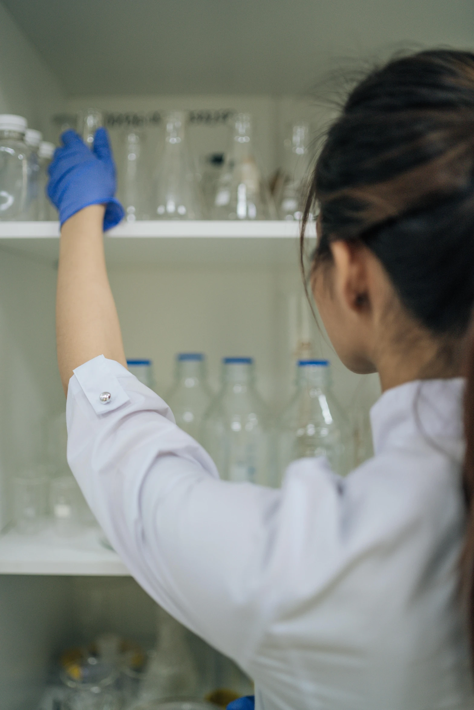 a female in a white shirt is picking soing out of a rack