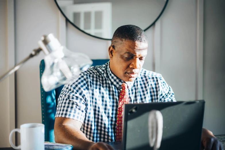 an african american man is at his desk using a computer