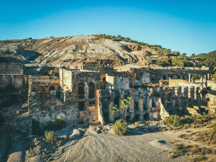 an abandoned town in the desert, surrounded by rocks and trees