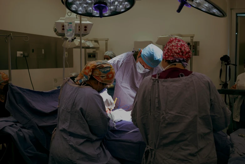  doctors are performing  on a man in the operating room