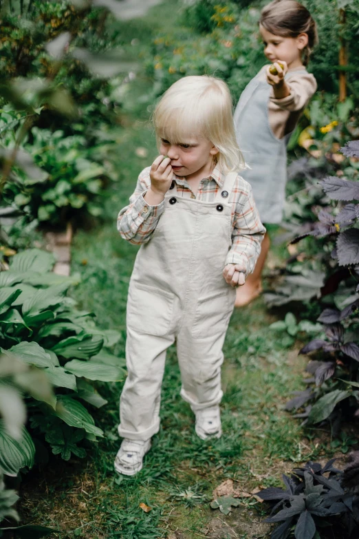 a small child is standing in a garden