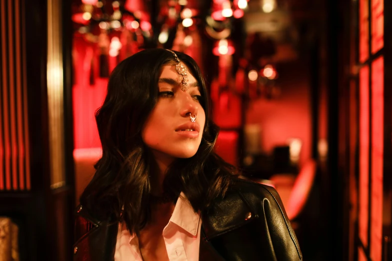 woman wearing leather jacket looking up in a room