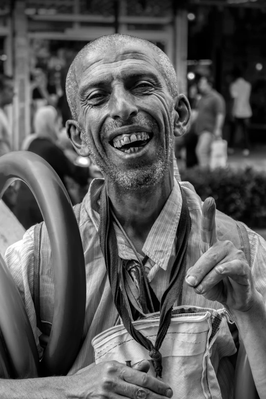 a man smiles as he holds a cup and shows his tongue