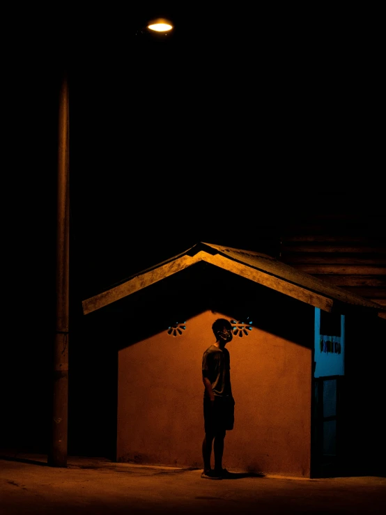 a man standing outside at night in front of a building