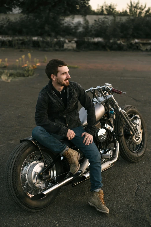 a man sitting on the front end of his motorcycle