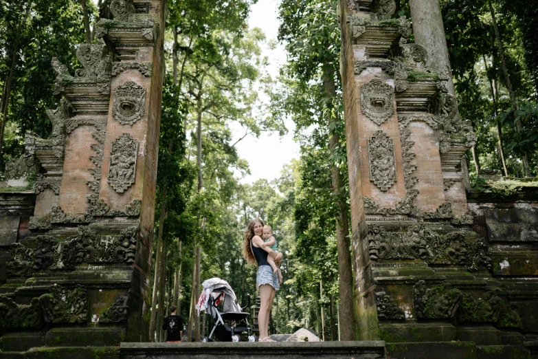 a woman and child taking pictures in an ancient stone temple