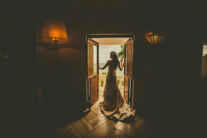 a woman standing outside a door way at night