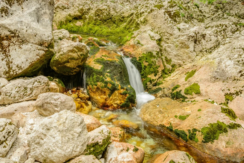 a small waterfall is coming down from the rocks