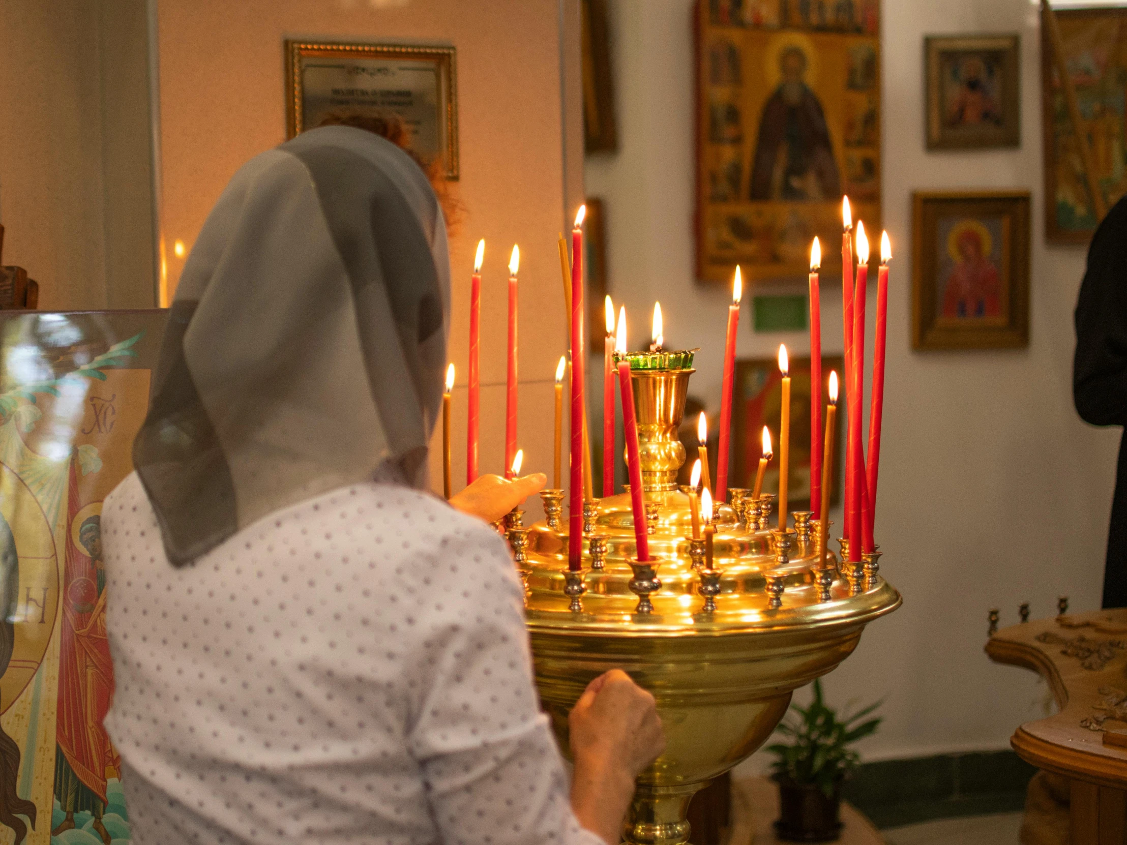 a nun with a veil on looking at candles