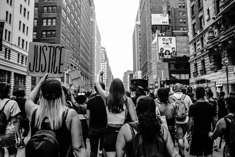 some women are holding signs on a crowded street