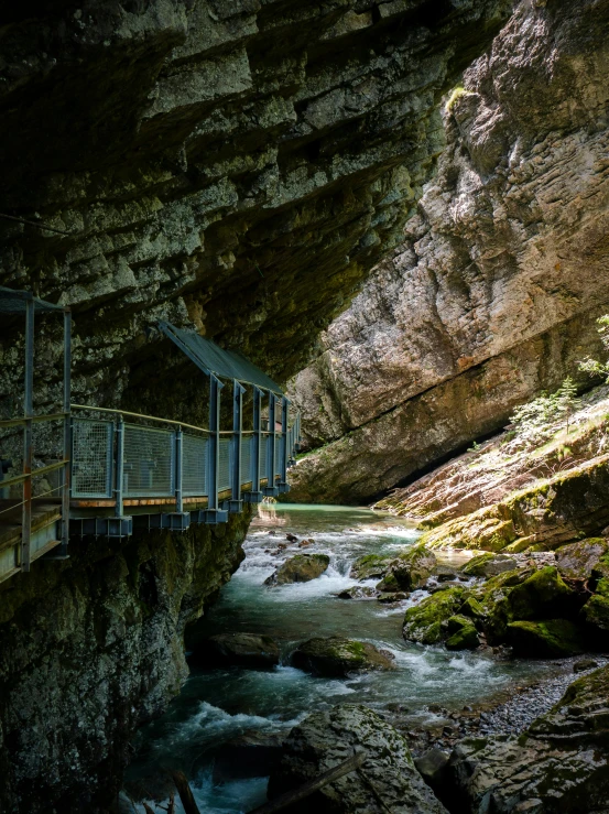 the walkway is going to a cave where water is flowing